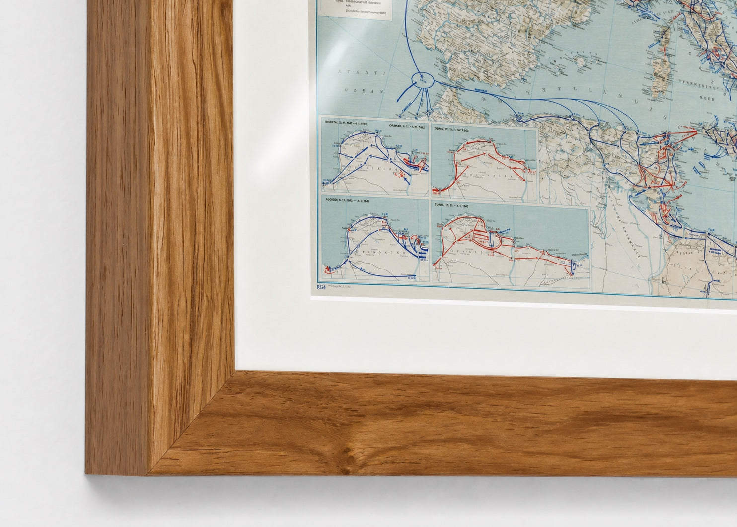 European theater strategic map in a Walnut Brown frame close-up showing the mitered corner, archival-white mat, glazing, and print surface.